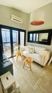 a living room with a white couch and a table at Very romantic seaview appartment with warm pool in Patalavaca