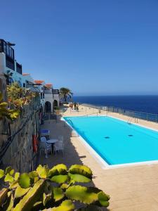 a swimming pool with the ocean in the background at Very romantic seaview appartment with warm pool in Patalavaca