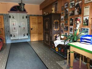 a room with a table and a cabinet with pictures on the walls at Doppelzimmer & Familienzimmer vom Friesenhof Wieratal in Nobitz