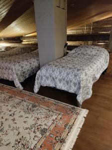 a bedroom with two beds and a rug at Villa Lilja in Muurame