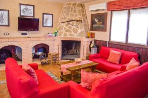 a living room with red couches and a fireplace at Casas Rurales Alhambra - Lagunas de Ruidera in Alhambra