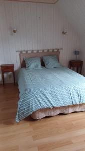 a bed with a blue comforter in a bedroom at La Bretagne ça vous gagne in Ploufragan
