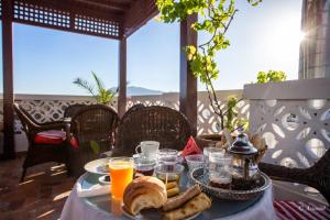 a table with a breakfast of bread and orange juice at Hotel Chams in Chefchaouene