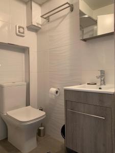 biała łazienka z toaletą i umywalką w obiekcie Gemütliches Appartement in Ano Poli w Salonikach