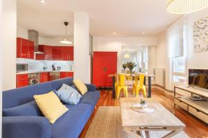 a living room with a blue couch and a table at City Centre & Museum by Next Stop Bilbao in Bilbao