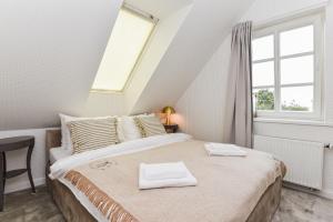 - une chambre avec un lit et 2 serviettes blanches dans l'établissement Saulėtasis Rytas, à Nido