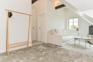 a living room with a white couch and a table at Saulėtasis Rytas in Nida