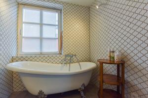 a bath tub in a bathroom with a window at Saulėtasis Rytas in Nida