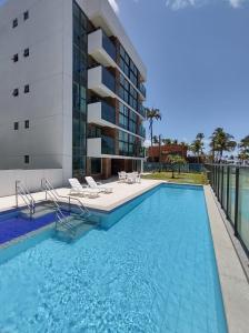 a swimming pool in front of a building at Rio Park Avenue Residence, Piedade - By TRH Invest in Recife