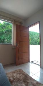 1 dormitorio con puerta de madera y ventana grande en hospedagem recanto do sábia 4, en Caparaó Velho