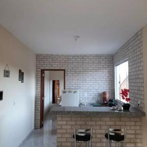 a kitchen with a counter and chairs in a room at pousada Montanhez ap3 in Caparaó Velho +18 photos