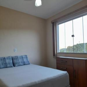 a bedroom with a bed and a large window at hospedagem recanto do sábia 4 in Alto Caparao