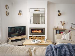a living room with a fireplace and a couch at Beach Boutique in Camber