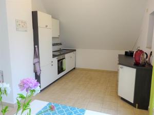 a small kitchen with white cabinets and a stove at Ferienanlage Waschbär Country in Templin