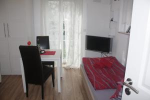 Zimmer mit einem Schreibtisch und einem Tisch mit einem Stuhl in der Unterkunft The Blue House in Erlangen