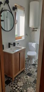 a bathroom with a toilet and a sink and a mirror at Domki Obertyny in Wetlina