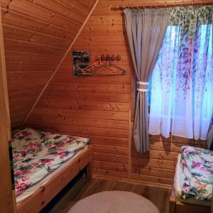 a bedroom with a bed in a log cabin at Domki Obertyny in Wetlina