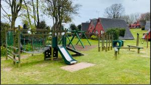a park with a playground with a slide at Foxes Sea Side Retreat Deluxe Chalet is a lovely holiday home tucked away on the Kent Coast in Kingsdown