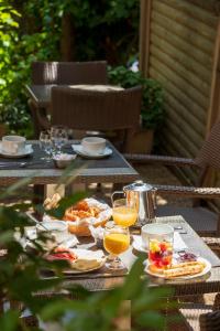 una mesa con platos de comida y vasos de zumo de naranja en Hôtel Le Mozart en Aix-en-Provence