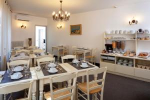 uma sala de jantar com mesas e cadeiras e uma cozinha em Hôtel Le Mozart em Aix-en-Provence