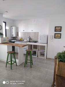 a kitchen with a table and two stools at Castex in Cordoba