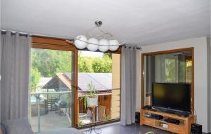 uma sala de estar com televisão e uma grande janela em Gorgeous Home In Marmoutier With Kitchen em Marmoutier