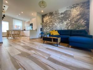 a living room with a blue couch and a table at Maison de ville au bord de l’eau (3) in Saint-Nicolas-de-Port
