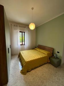 a bedroom with a bed with a yellow bedspread at La Cannucciola in Piediluco