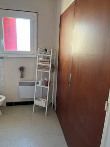 a bathroom with a toilet and a wooden door at Gîte de la bastide in Monteux