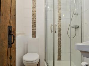 a bathroom with a toilet and a glass shower at Beck Cottage in Ambleside