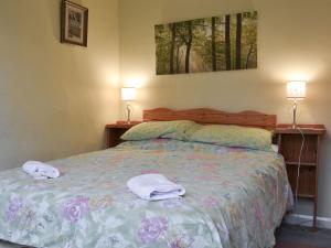 a bedroom with a bed with towels on it at Beck Cottage in Ambleside