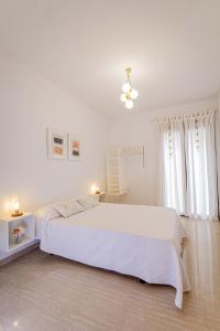 a white bedroom with a large bed and a window at Villa Viana in Rute