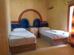 Postel nebo postele na pokoji v ubytování Les Pyramides Hotel Merzouga