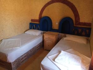 Postel nebo postele na pokoji v ubytování Les Pyramides Hotel Merzouga
