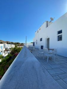 a patio with chairs and a table next to a building at Helliniko Hotel in Parikia