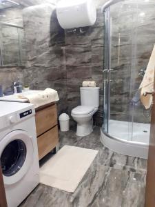 a bathroom with a washing machine and a toilet at Panoramic Penthouse Haven in Mellieħa