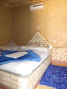 Postel nebo postele na pokoji v ubytování Les Pyramides Hotel Merzouga