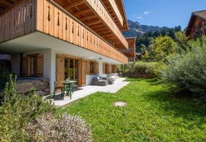 a backyard of a house with a patio at Panoramapark Soleil B Garden Apartment in Wengen