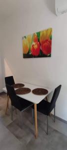 セゲドにあるMérey Apartmentのテーブルと椅子2脚、壁画