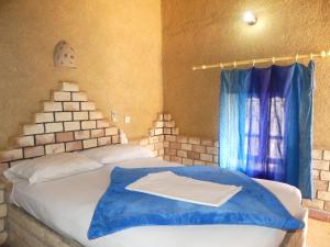 Postel nebo postele na pokoji v ubytování Les Pyramides Hotel Merzouga