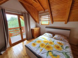 ein Schlafzimmer mit einem Bett mit Sonnenblumen darauf in der Unterkunft Pan Koran Vikendica Pale, Jahorina in Pale