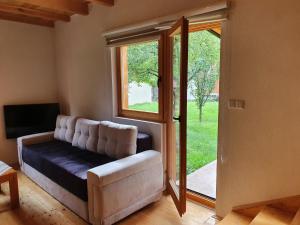 a living room with a couch and a sliding glass door at Pan Koran Vikendica Pale, Jahorina in Pale