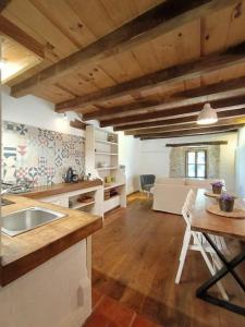 uma cozinha com um lavatório e uma mesa num quarto em Granja Labrada: Alojamiento con caballos em Mañón