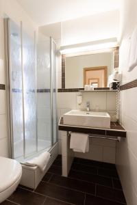 a bathroom with a sink and a shower at Europa Kehl Hotel in Kehl am Rhein