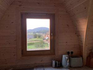 a window in a wooden room with a view at Hedgehog Glamping Pod in Leighton