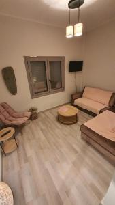 吉雄的住宿－Larry's little place in the center of Gytheio，客房设有两张床、一张沙发和一台电视。