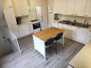 a kitchen with white cabinets and a wooden table at Wanha Koulu Tahko Onnela, 4mh, Palju, Sauna, Tupakeittiö, Wifi, Liikuntasali, RinteetSpaRavintola 6km, Lemmikit OK, Edukas in Reittiö