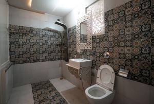 a bathroom with a toilet and a sink at Lillywoods Zac Beach Resort, Calangute in Goa Velha