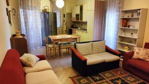 a living room with two couches and a kitchen at CASA SOPRANO da Anita in Messina