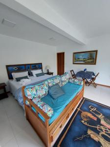 a bedroom with a large bed and a couch at Lumiar Eco Lodge - Chalé Telhado Verde in Nova Friburgo +34 photos